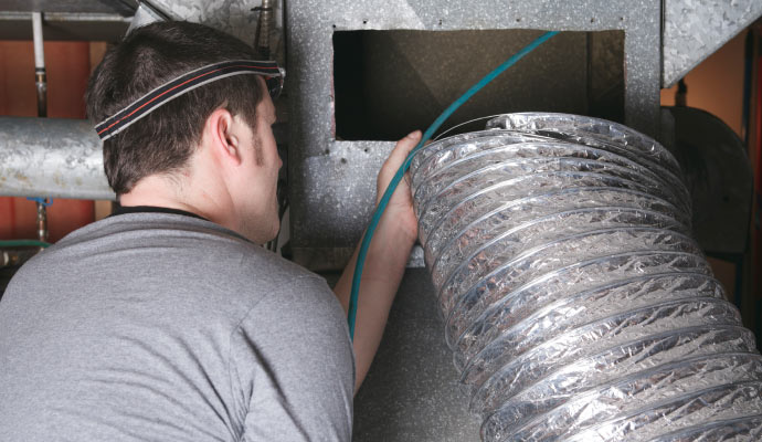 professional worker cleaning air duct