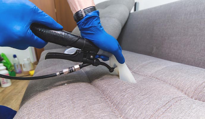 Person cleaning upholstery with a vacuum cleaner