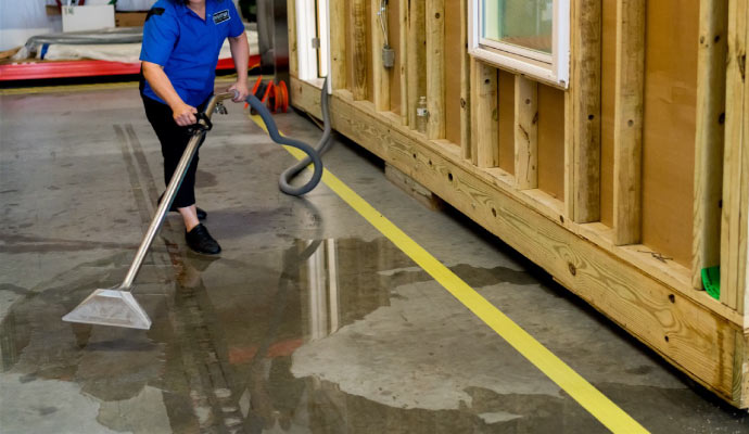 worker cleaning water from the floor