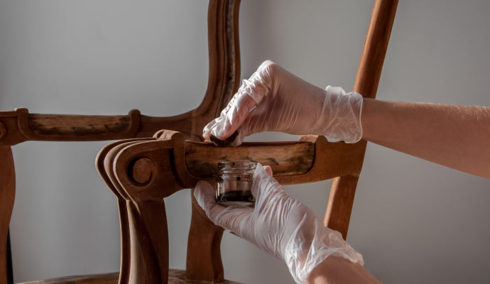 An expert polishing a wooden furniture