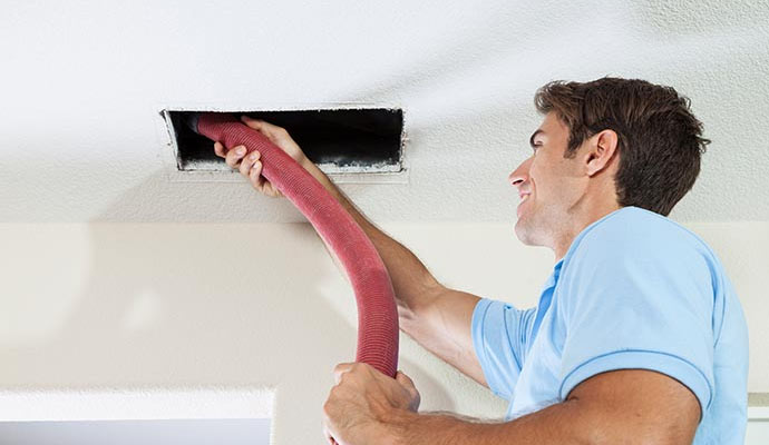 Professional worker cleaning air duct.