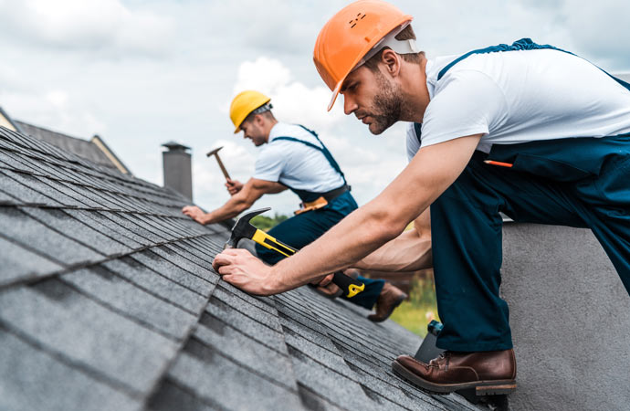 a couple of professionals installing roof