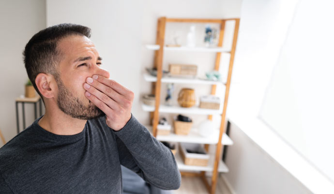 Man covering mouth for smoke odor