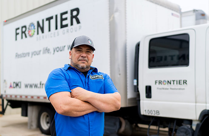 a frontier professional standing in front of their service van