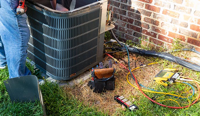 Technician performing maintenance on an outdoor air conditioning unite