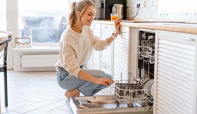 Person loading a clean dishwasher