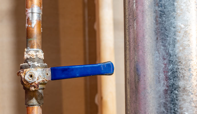 A corroded water shut-off valve on a copper pipe