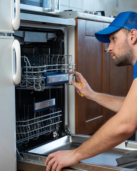 Technician repairing a dishwasher