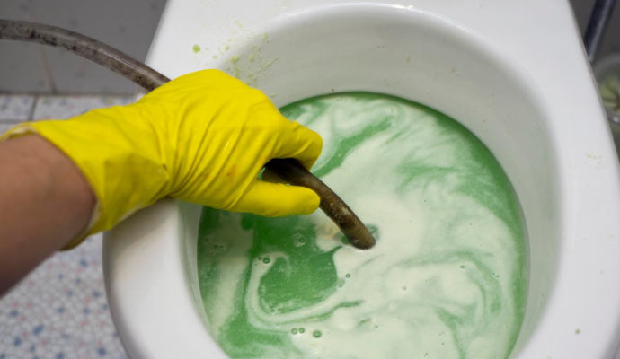 a person cleaning up a toilet