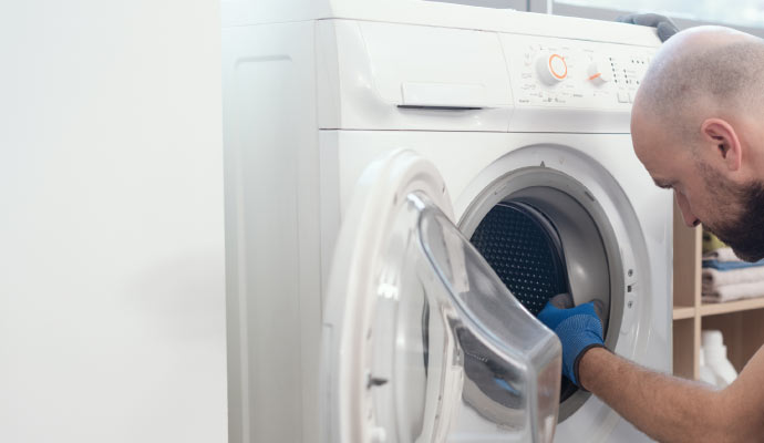 A professional repairing a washing machine