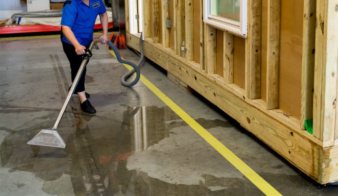 professional worker cleaning water on the floor